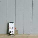 Een smartphone met een mobiele bankieren app op het scherm, omringd door financiële documenten en een laptop voor een moderne uitstraling.